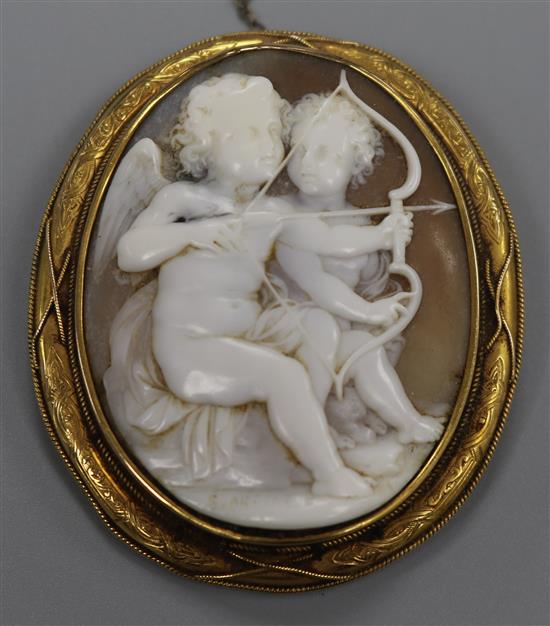 A Victorian yellow metal mounted cameo brooch, carved with Cupids, signed G. Arsene?, 62mm.